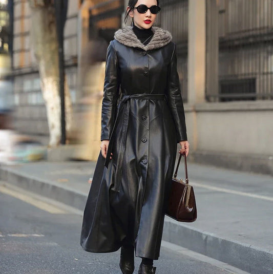 Women's Flared Hooded Coat in Onyx (Seven-Eighths Length). Model presents the commanding full-length silhouette, accentuated by a mink fur hood and sculptural leather flow. Borcelleclothes.