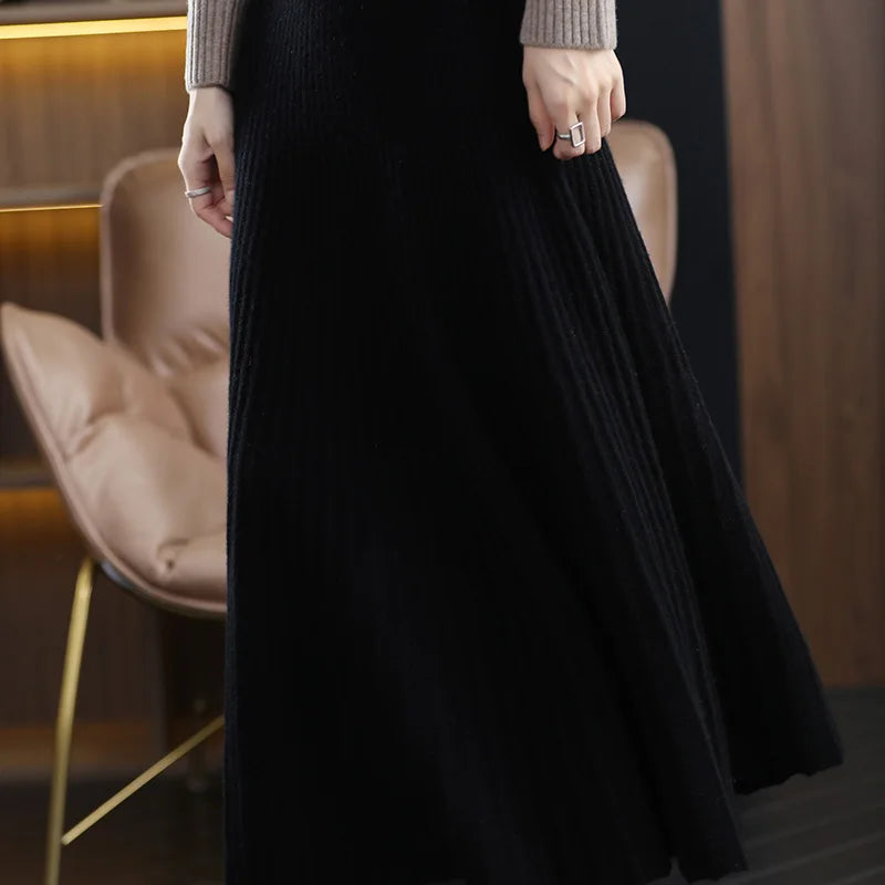 Model slightly turned in the Onyx version of the Flaring Lines Merino Skirt, revealing the curved motion of the pleats — From Borcelleclothes.