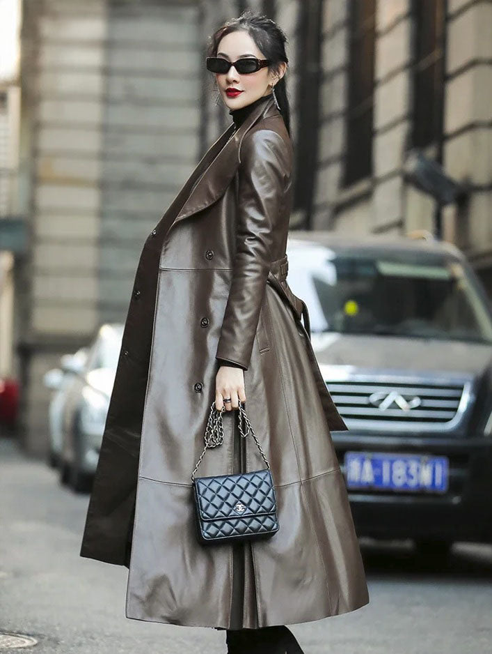 Women's Flowing Leather Coat in Taupe. Side profile emphasizing the coat’s elongated lines, structured elegance, and fluid pleating. Borcelleclothes.
