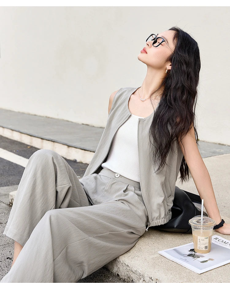 Model in French Grey set sitting on a concrete step in an urban setting. From Borcelleclothes.