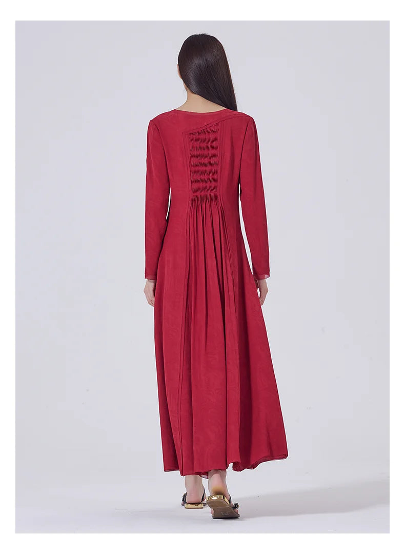 Back view of the dress with visible diagonal yoke and petal-like tucked panel beneath. From Borcelleclothes.