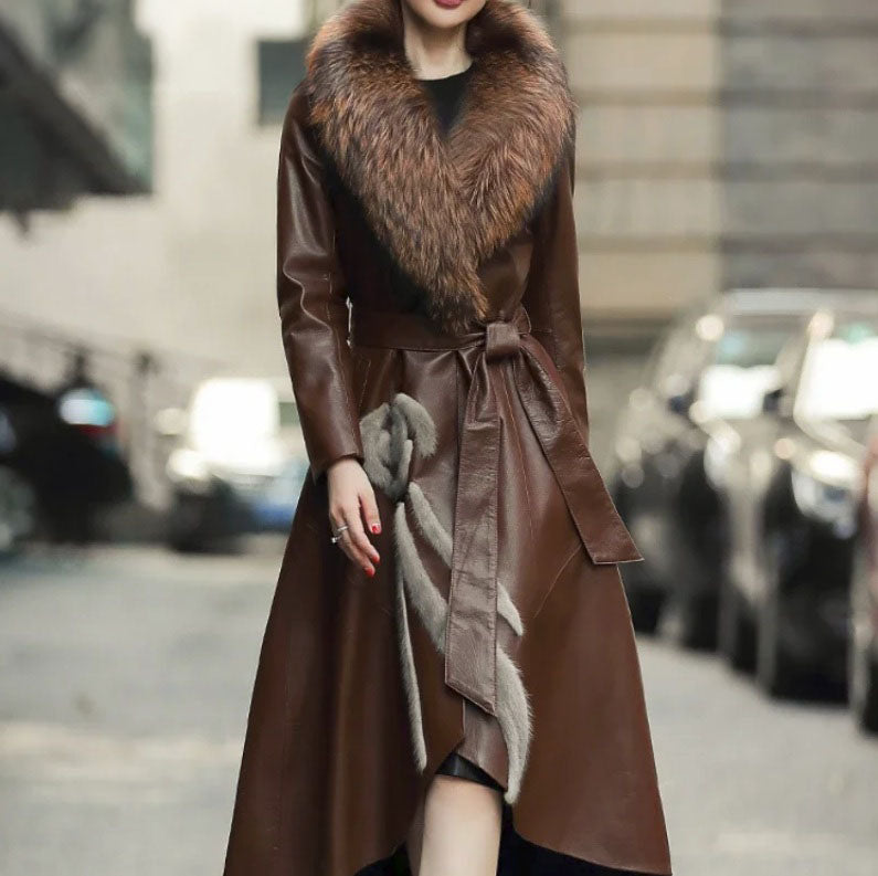 Women's Goatskin Down Coat in Irish Coffee. Model moves forward, showcasing the wrap design, belted waist, and sculptural high-low hem. Borcelleclothes.