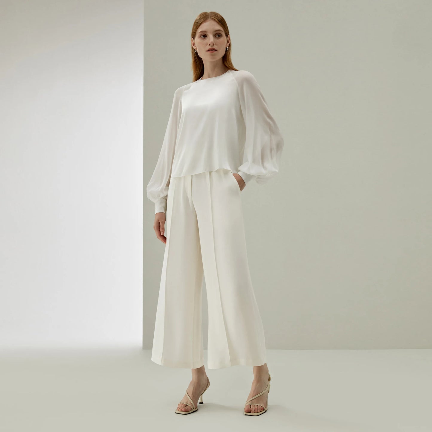 Model in Pearl Bush wide-leg silk trousers, hand resting in the pocket — a moment of quiet poise and tactile elegance. From Borcelleclothes.