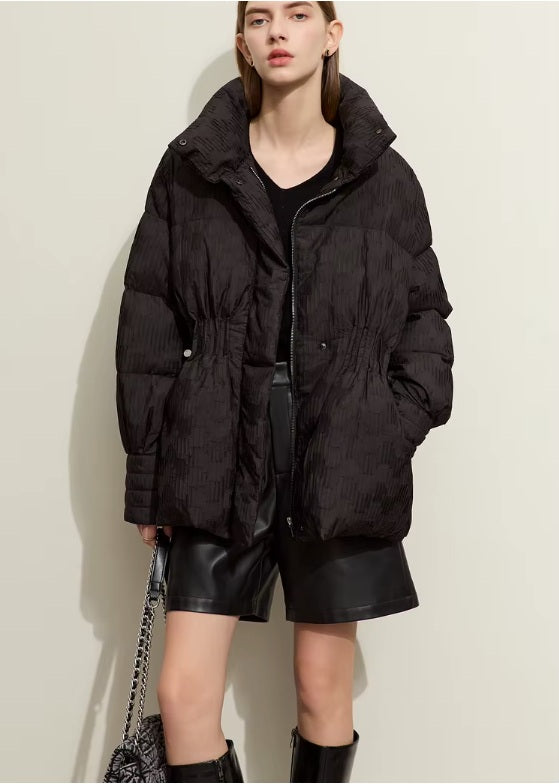 Model holding a bag with one hand in pocket while wearing the Onyx jacquard down jacket. From Borcelleclothes.