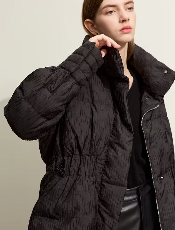 Model touching her chin while wearing the Onyx jacquard down jacket. From Borcelleclothes.