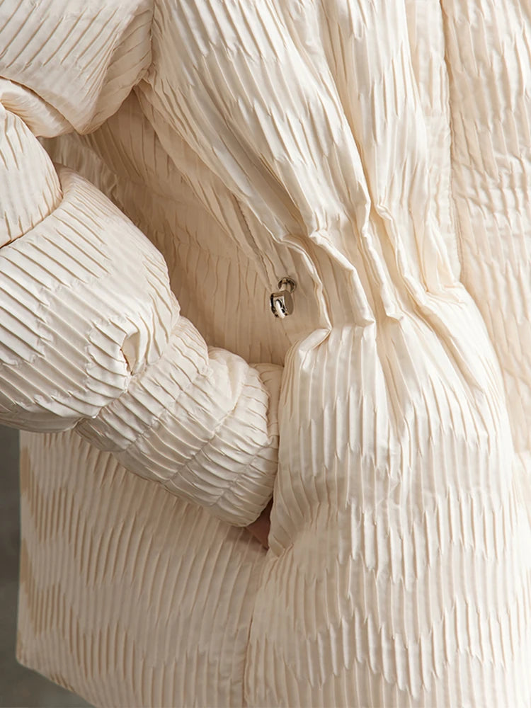 Model in the Pearl Bush jacquard down jacket with hand in pocket, waist section visible. From Borcelleclothes.