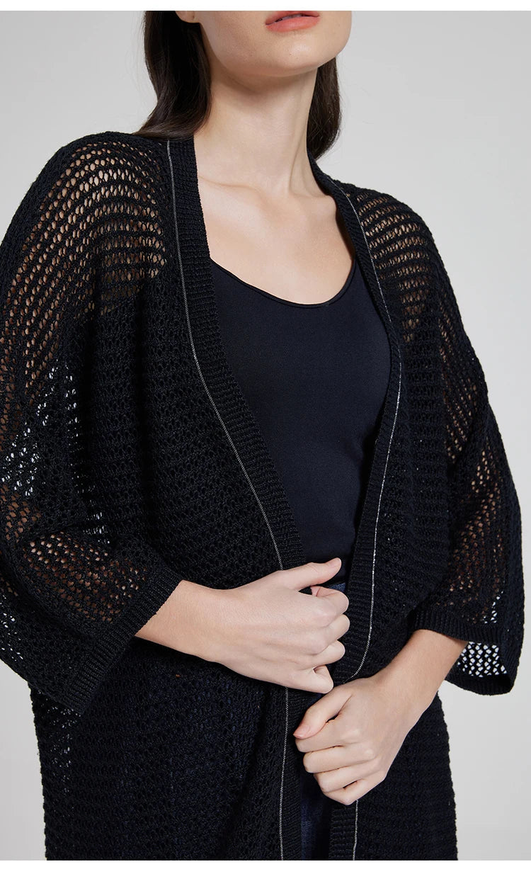 Model wearing the Onyx lace overlay, gently touching the open edges of the garment. From Borcelleclothes.