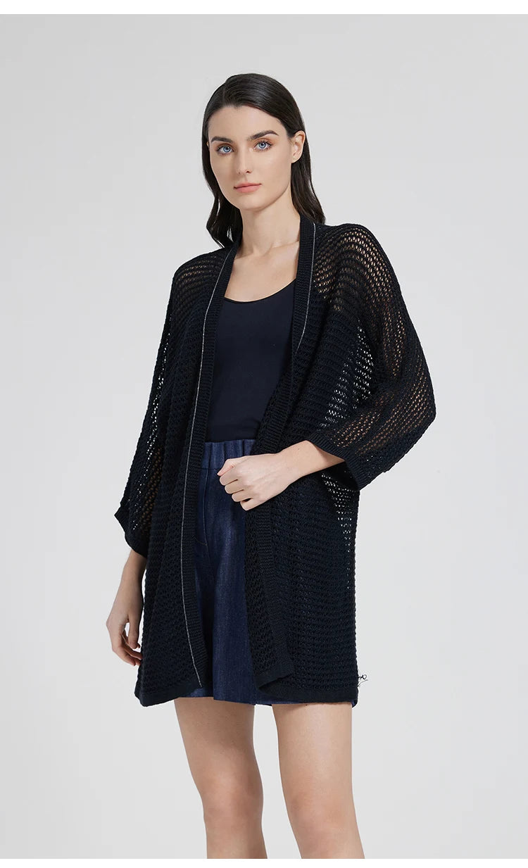 Side view of the Onyx kimono-style overlay as the model turns slightly, accentuating the sheer knit and chain trim. From Borcelleclothes.