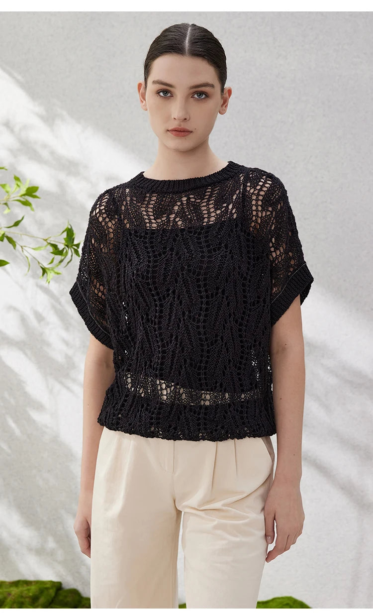 Front-facing view of black linen lace top with arms straight down, revealing batwing construction and bold hollow motif. From Borcelleclothes.