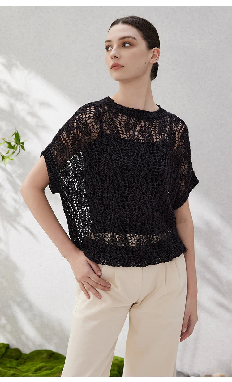 Close shot of model in black lace linen top, head turned to the side, drawing attention to neckline and sleeve shape. From Borcelleclothes.