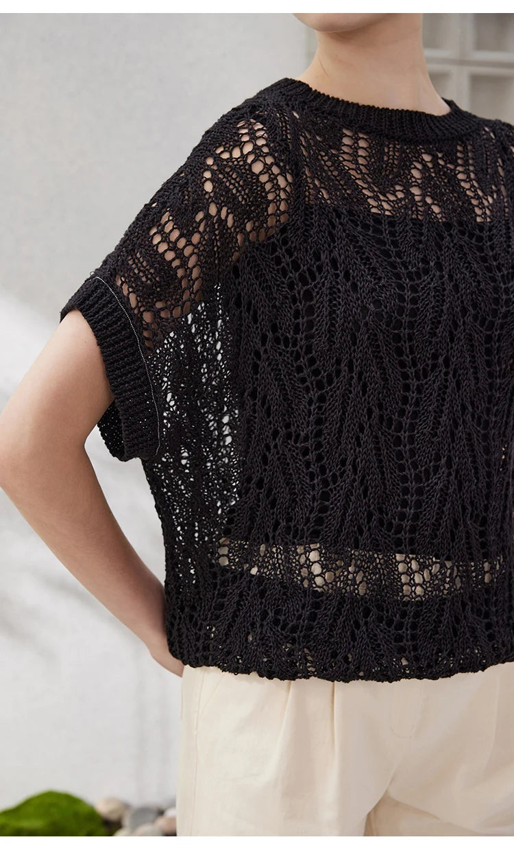 Model in Onyx lace top bending her arms slightly to emphasize the batwing sleeve and airy, architectural drape.