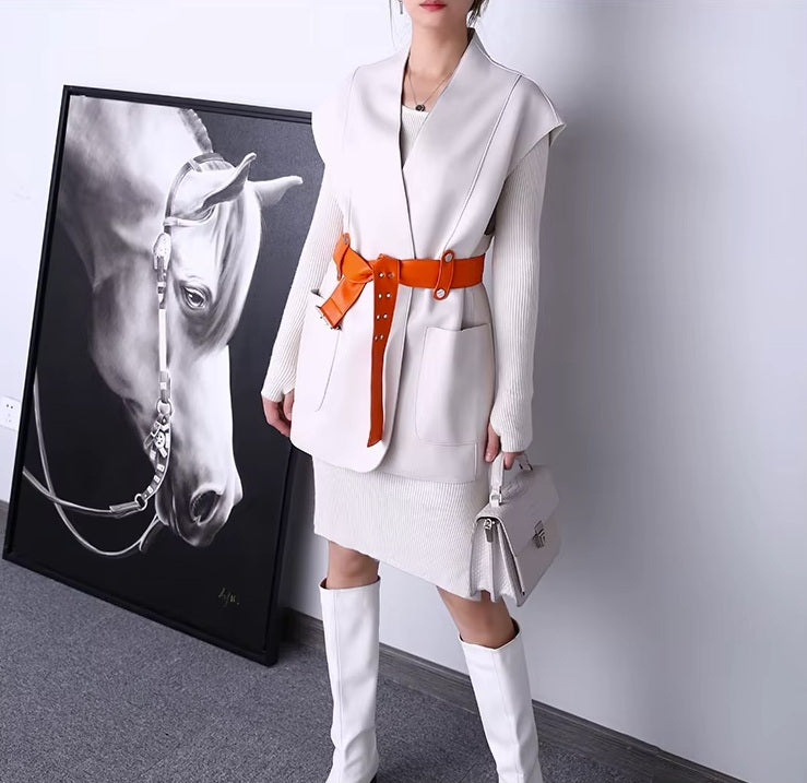 Women's Leather Wrap Vest in Magnolia. Model holds a structured bag, emphasizing the vest’s refined layering potential and modern contrast details. Borcelleclothes.