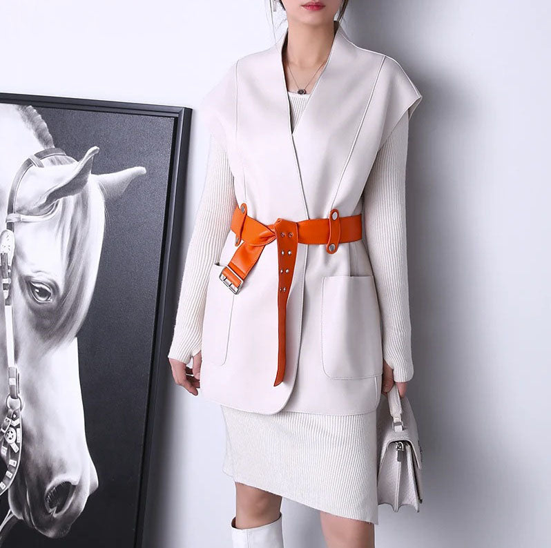 Women's Leather Wrap Vest in Magnolia. Model stands straight, showcasing the structured drop-shoulder silhouette and bold contrast belt that defines the waist. Borcelleclothes.