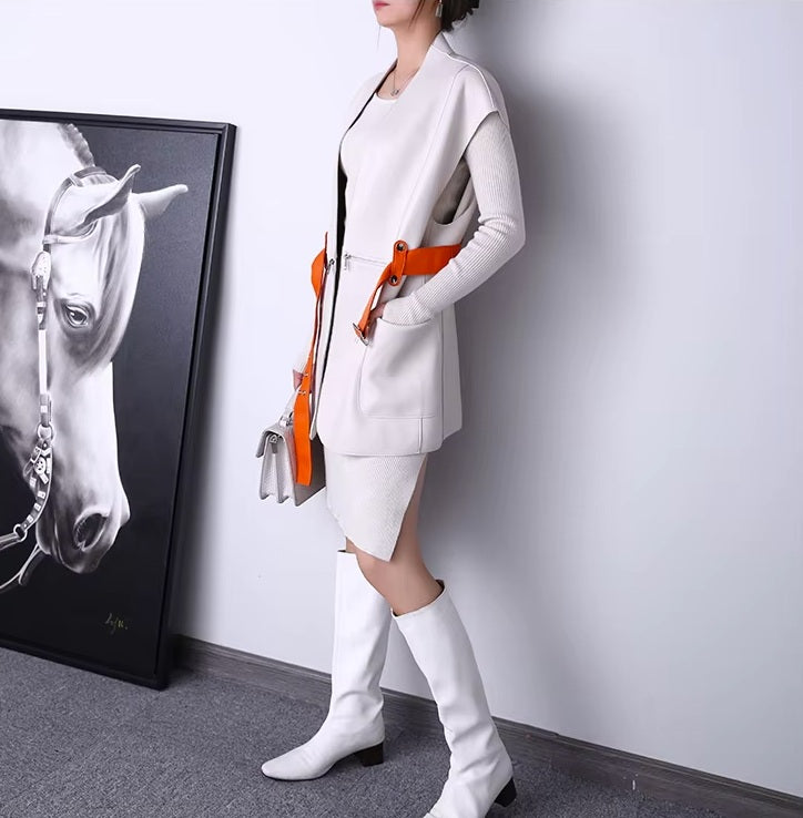 Women's Leather Wrap Vest in Magnolia. Model wears the vest with the belt unfastened, revealing hidden waist zippers and an effortlessly structured fit. Borcelleclothes.