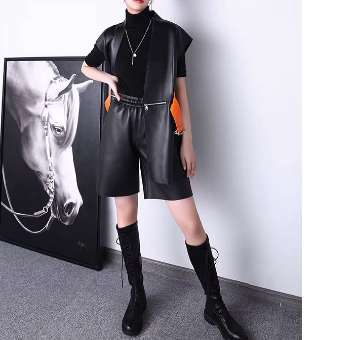 Women's Leather Wrap Vest in Onyx. Model wears the vest unfastened, showcasing the contrast belt and fluidity of the wrap design. Borcelleclothes.