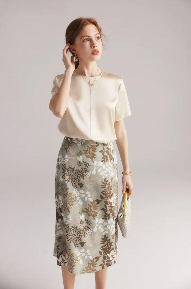 Model gently touching hair while wearing Lemon Grass silk skirt, showing relaxed poise and light movement. From Borcelleclothes.