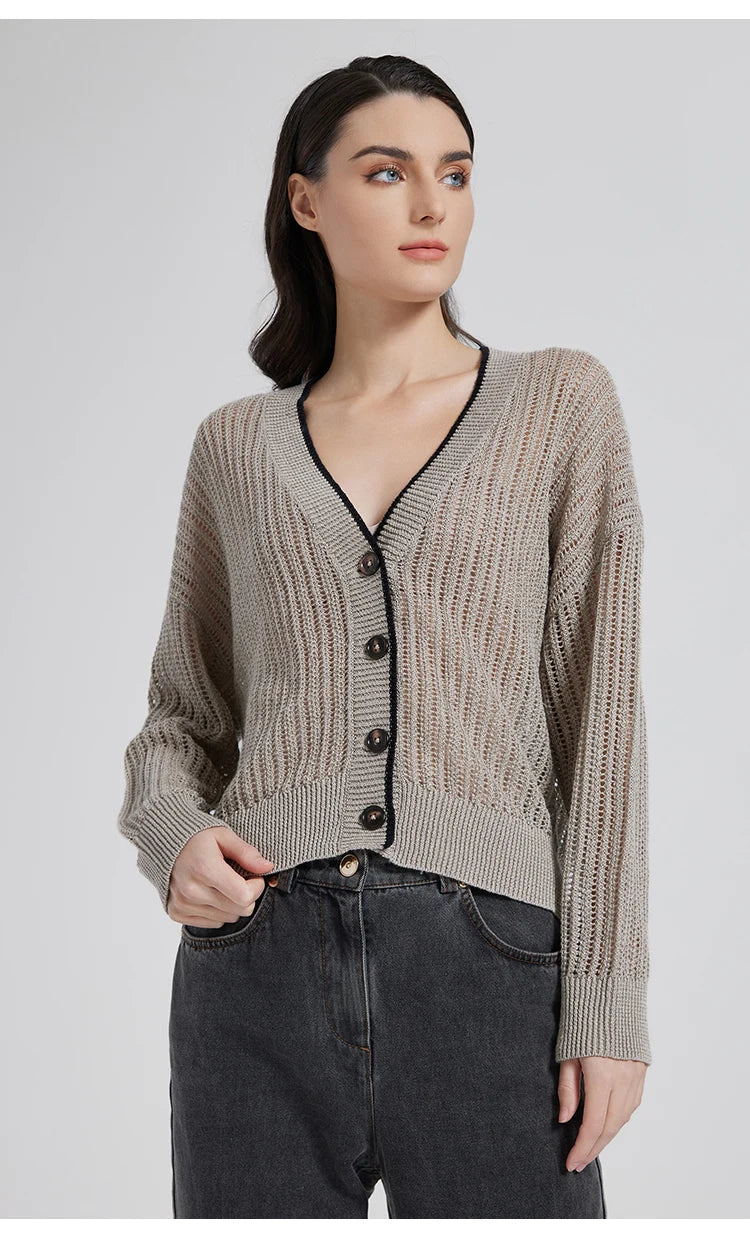 Close shot of Tide linen cardigan with one hand in pocket, showcasing contrast button, rib trim, and lace detail. From Borcelleclothes.