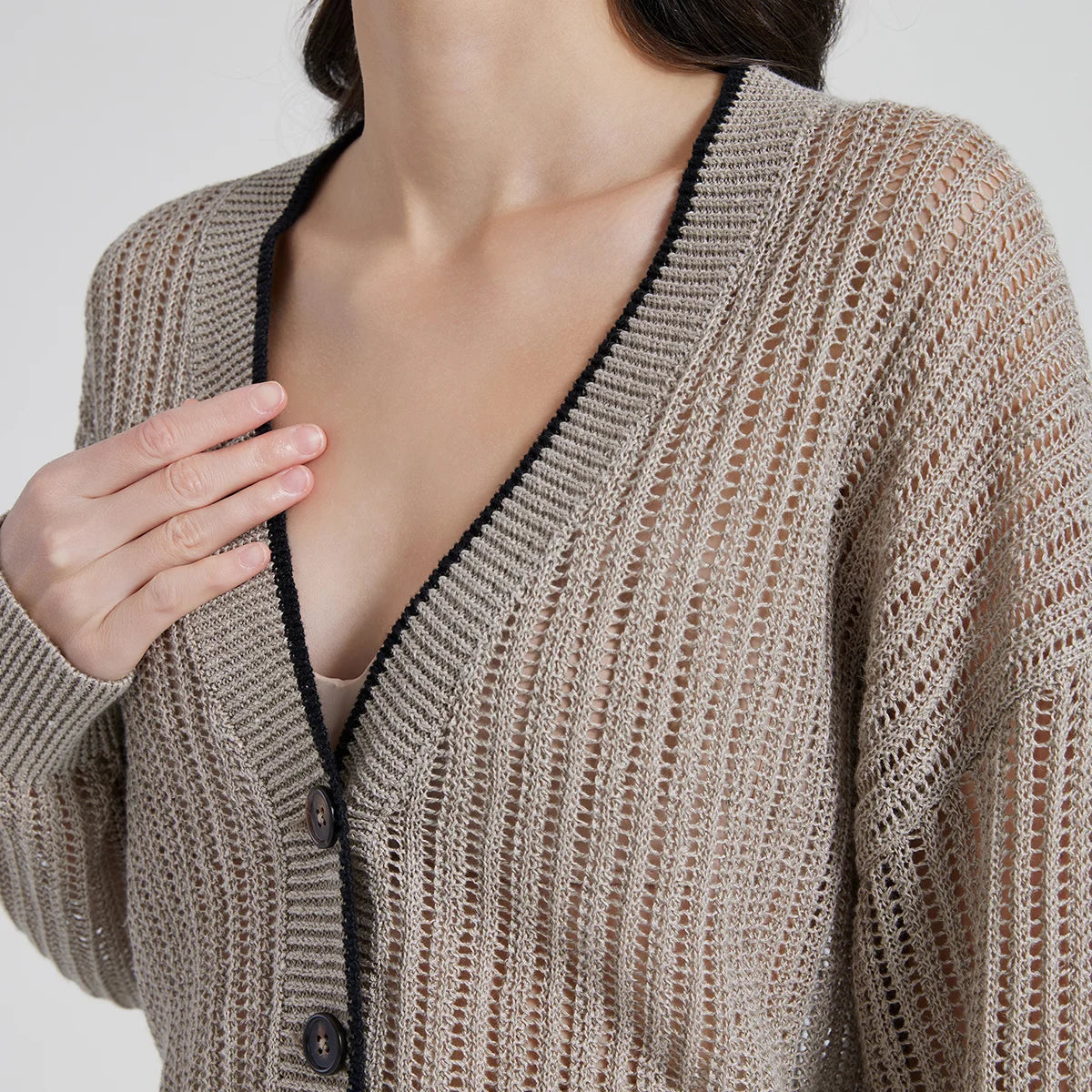 Upper part of Tide linen cardigan, emphasizing neckline, button placket, and dropped shoulders with ribbed trim. From Borcelleclothes.