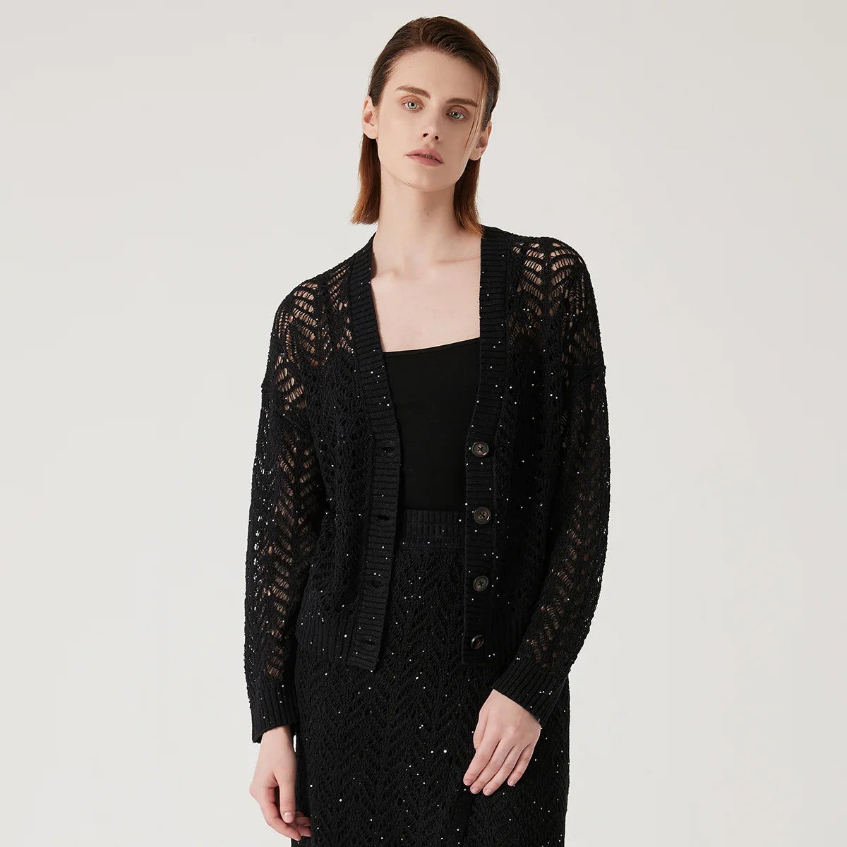 Women's linen lace cardigan in Onyx, featuring a flowing openwork pattern, ribbed cuffs, and a wide hem for gentle structure. From Borcelleclothes.
