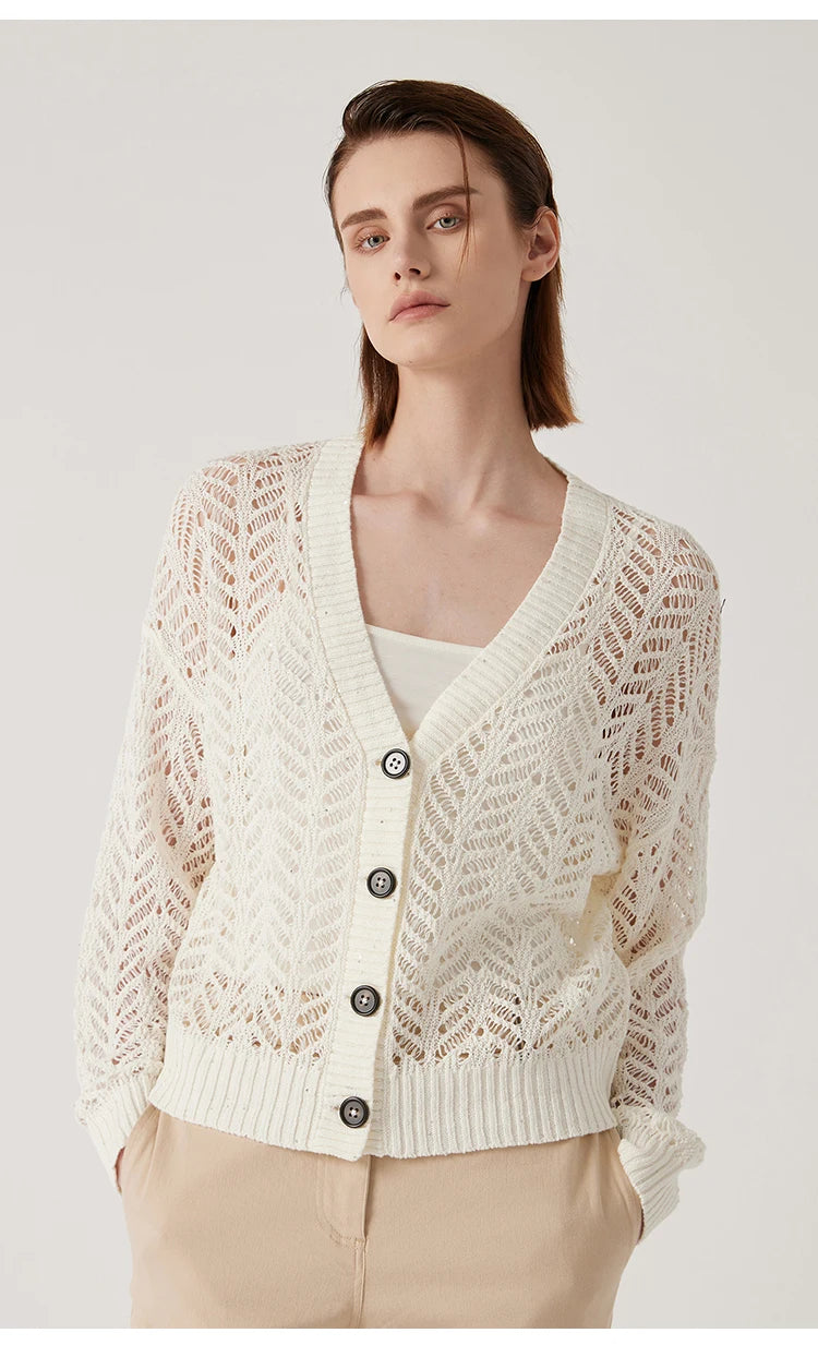 Pearl Bush cardigan styled with white trousers, model’s hands in pockets for a relaxed silhouette. From Borcelleclothes.