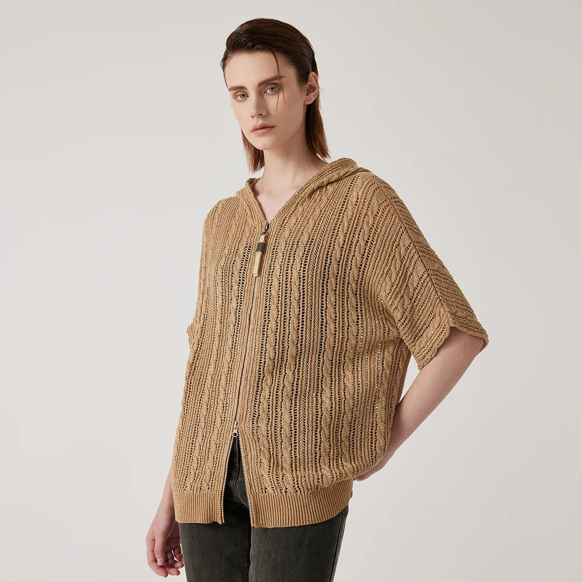 Woman in mocha lace hoodie, slightly bending to the side, highlighting the transparency and braided details in motion. From Borcelleclothes.