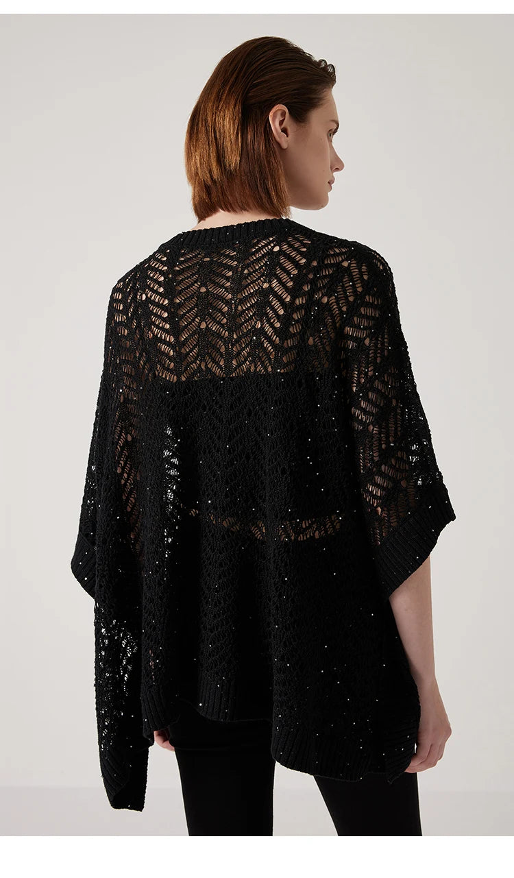 Back view of black linen poncho, rectangular shape and airy knit forming a quiet architectural silhouette. From Borcelleclothes.