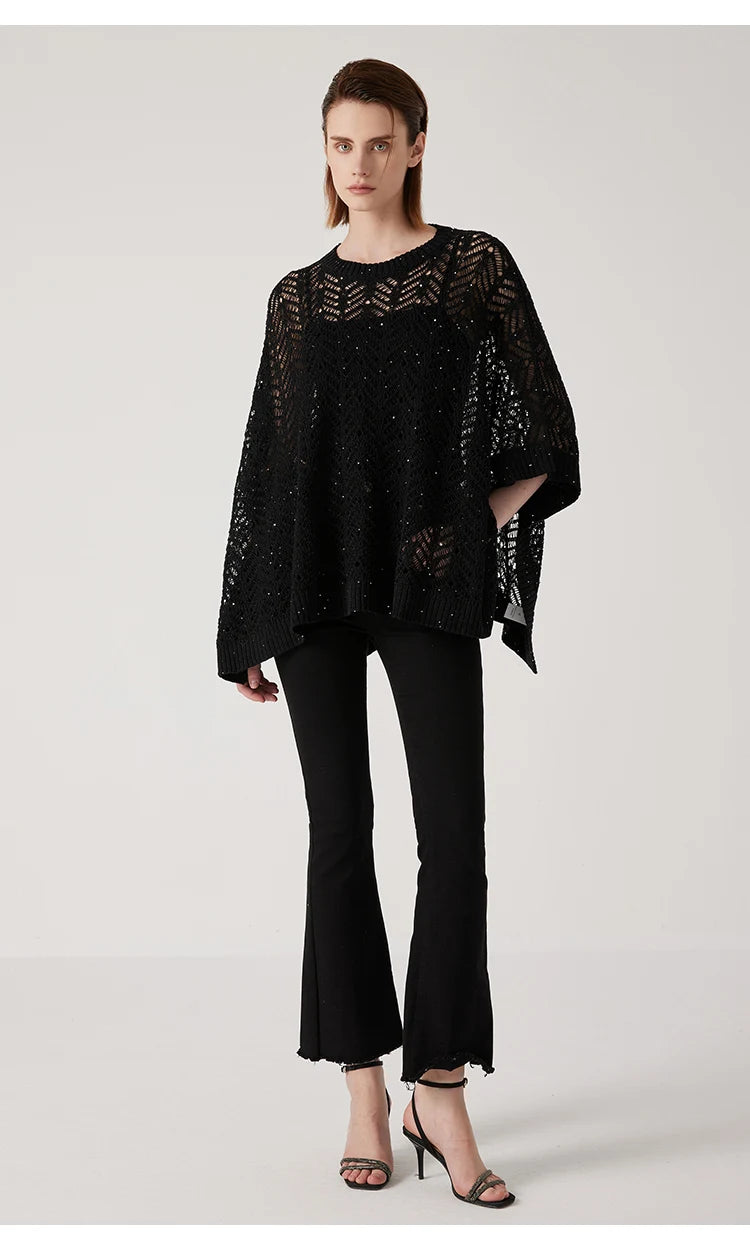 Full-length view of black linen lace poncho, softly structured drape and silver accents creating a luminous presence. From Borcelleclothes.