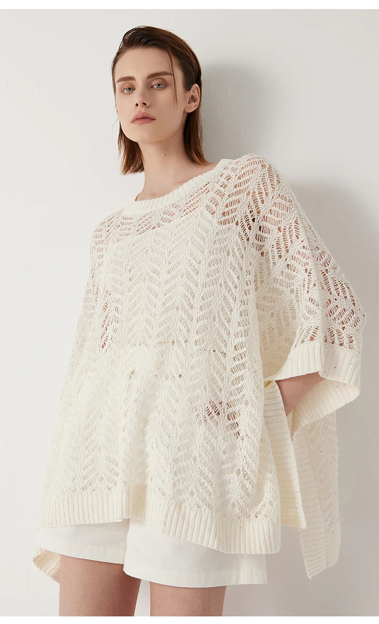 Pearl Bush poncho styled with white shorts, hand in pocket, and abstract knit glinting subtly in the light. From Borcelleclothes.