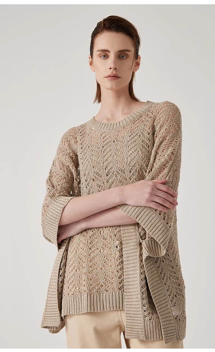Woman in Vanilla poncho with arms crossed, abstract lace forming a light-drenched aura around the body. From Borcelleclothes.