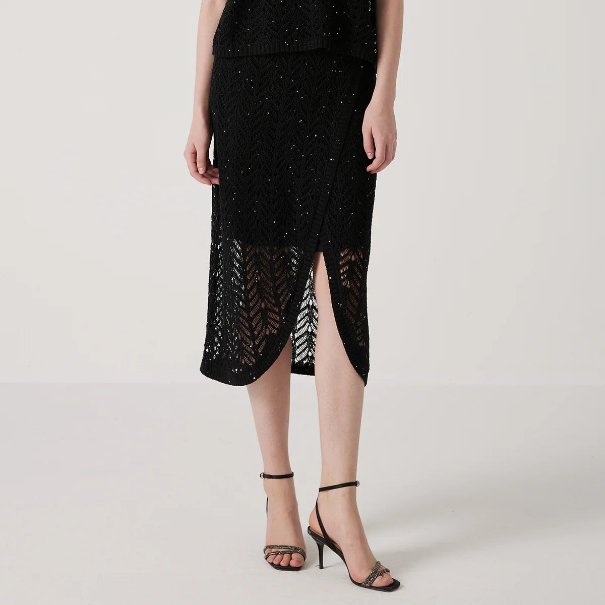 Linen lace skirt in Onyx with delicate openwork pattern and soft drape, highlighting the airy texture and gentle transparency of the knit. From Borcelleclothes.