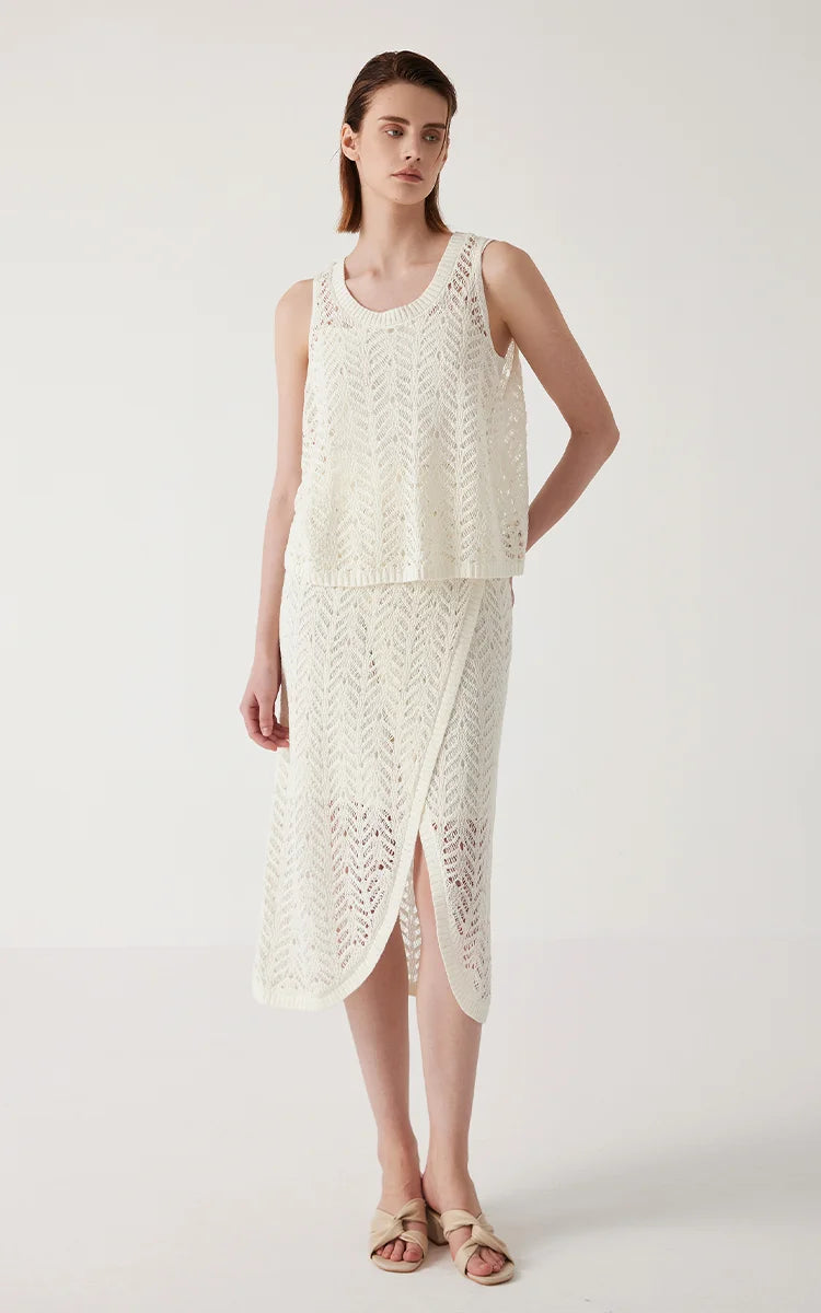 Model in Pearl Bush linen lace skirt with one hand behind her back, showing the skirt’s side relief and movement. From Borcelleclothes.