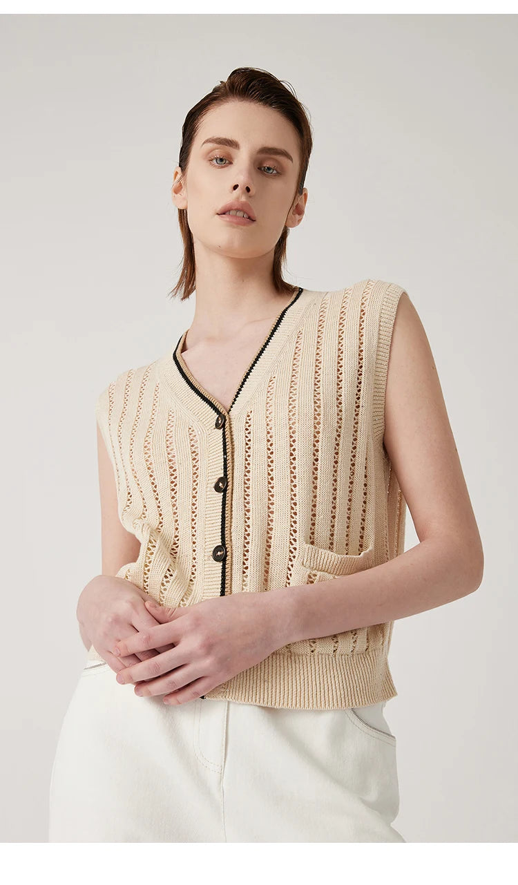 Almond lace vest with model touching fingertips softly, emphasizing lightness of the fabric and vertical alignment. From Borcelleclothes.