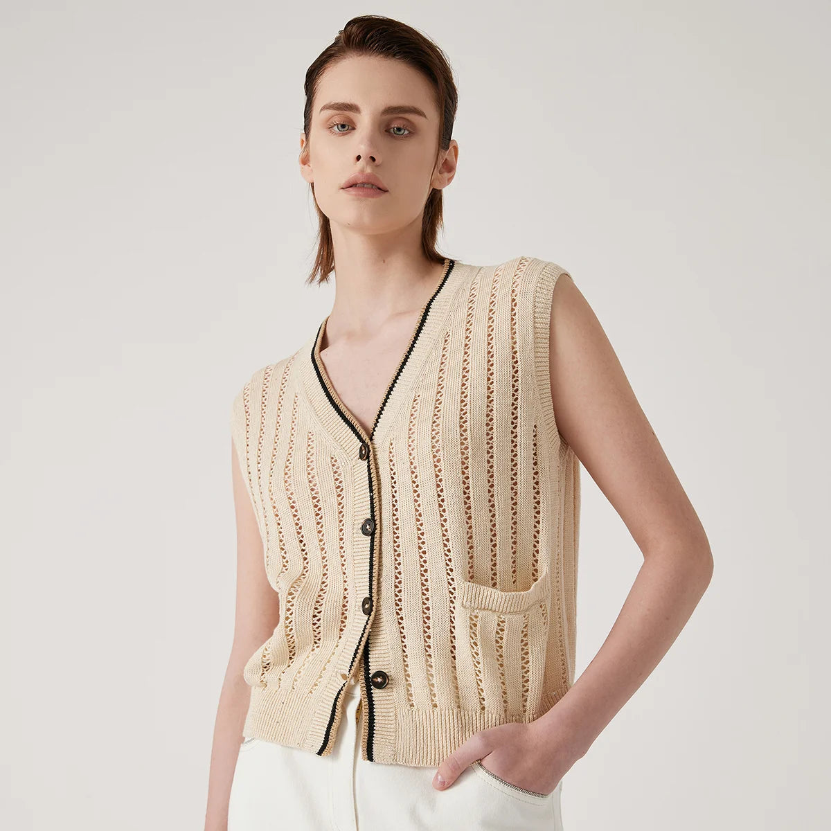 Women's linen lace vest in Almond with vertical stockinette and lace stripes, contrast ribbed trim, and a single patch pocket—minimal, structured, and quietly striking. From Borcelleclothes.