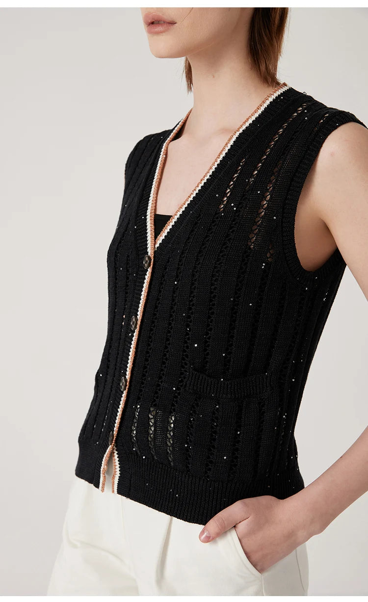 Model in Onyx lace vest with one hand in white pants pocket, revealing balanced structure and airy vertical knit. From Borcelleclothes.