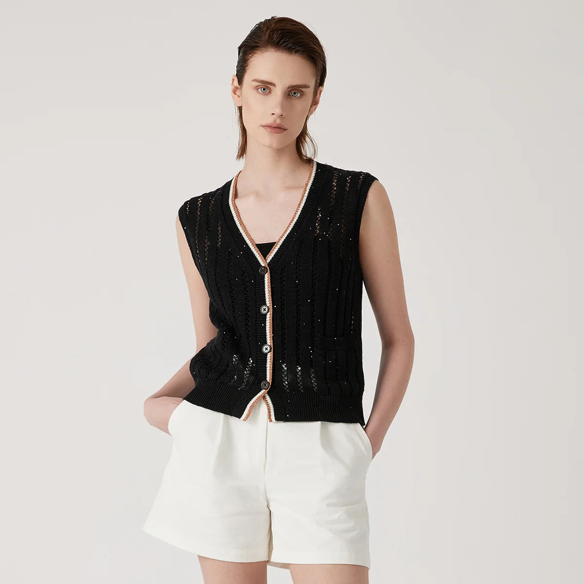 Women's linen lace vest in Onyx with vertical stockinette and lace stripes, contrast ribbed trim, and a single patch pocket—minimal, structured, and quietly striking. From Borcelleclothes.