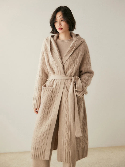Women's Luxurious Cable-Knit Cashmere Coat in Soft Amber, featuring intricate cable patterns, a loose-fitting silhouette, a wide ribbed bottom hem, large functional pockets, and an integrated hood for a timeless yet modern design, Borcelleclothes.