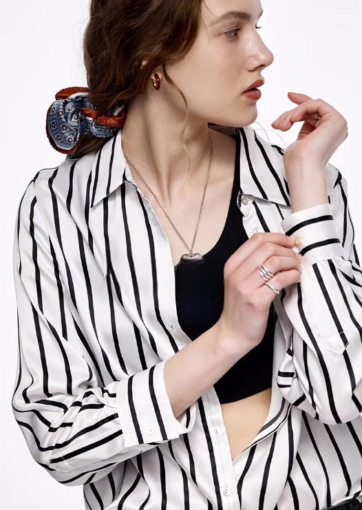 Model touching the cuff of the unbuttoned Women's Luxury 6A Mulberry Silk Shirt in Striped Black & White, showing attention to detail and luxurious fabric. From Borcelleclothes.