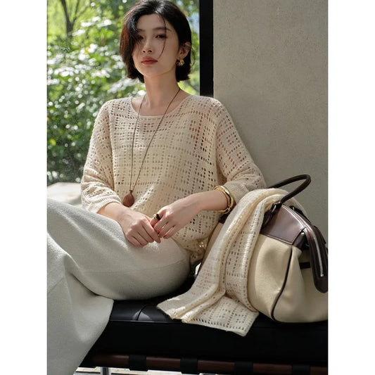 Model sitting on a sofa in the Meander cashmere top in Pearl Bush – From Borcelleclothes.