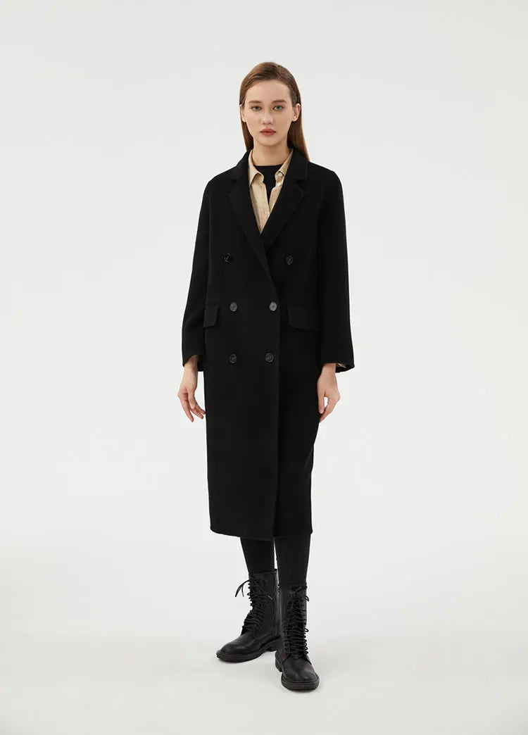 Model stepping forward in the Women's Minimalist Long Wool Coat in Onyx, highlighting its classic double-breasted design and sleek silhouette. From Borcelleclothes.