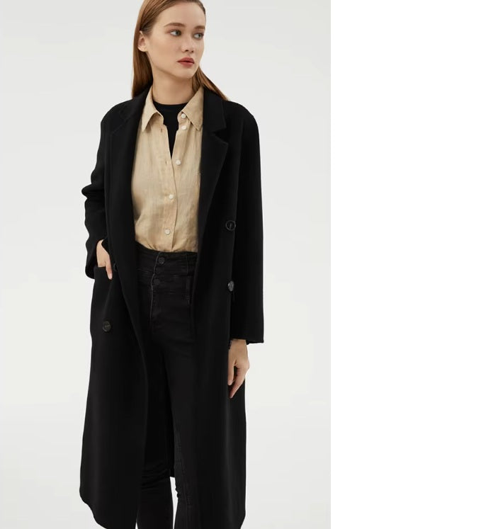 Model wearing the Women's Minimalist Long Wool Coat in Onyx, with one hand in the side pocket, showcasing the coat's tailored elegance and functionality. From Borcelleclothes.