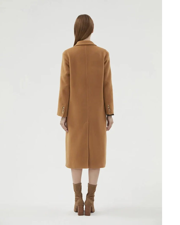 The back of the Women's Minimalist Long Wool Coat in Potters Clay, showcasing its mid-calf length and timeless design. From Borcelleclothes.
