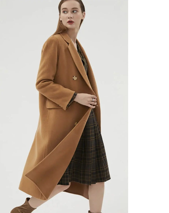 Model wearing the Women's Minimalist Long Wool Coat in Potters Clay, shown from the side to emphasize its warm hue and clean silhouette. From Borcelleclothes.