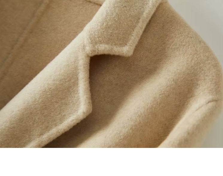 The lapel and shoulder of the Women's Minimalist Long Wool Coat in Vanilla, highlighting its clean lines and precise tailoring. From Borcelleclothes.