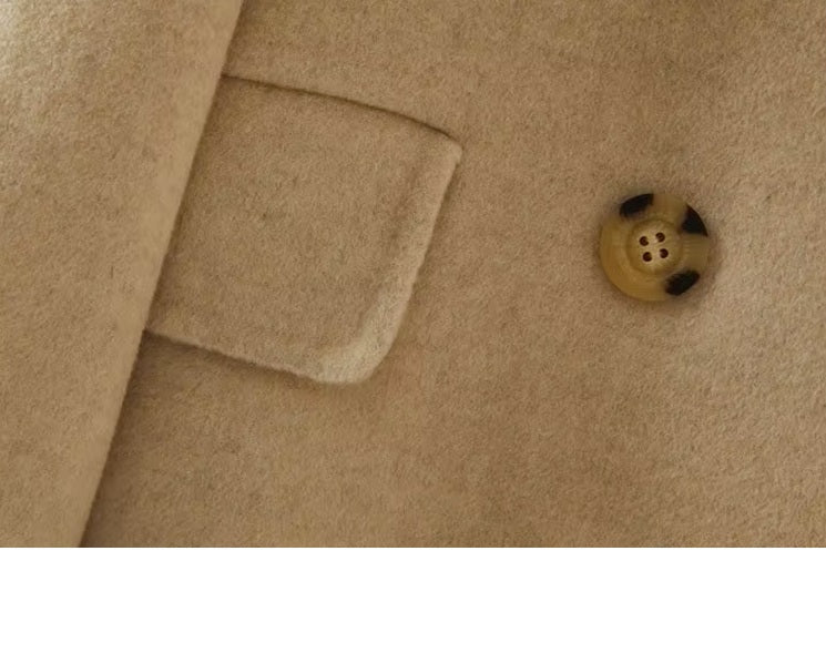 The sleeve, flap pocket, and a button on the Women's Minimalist Long Wool Coat in Vanilla, emphasizing refined craftsmanship. From Borcelleclothes.