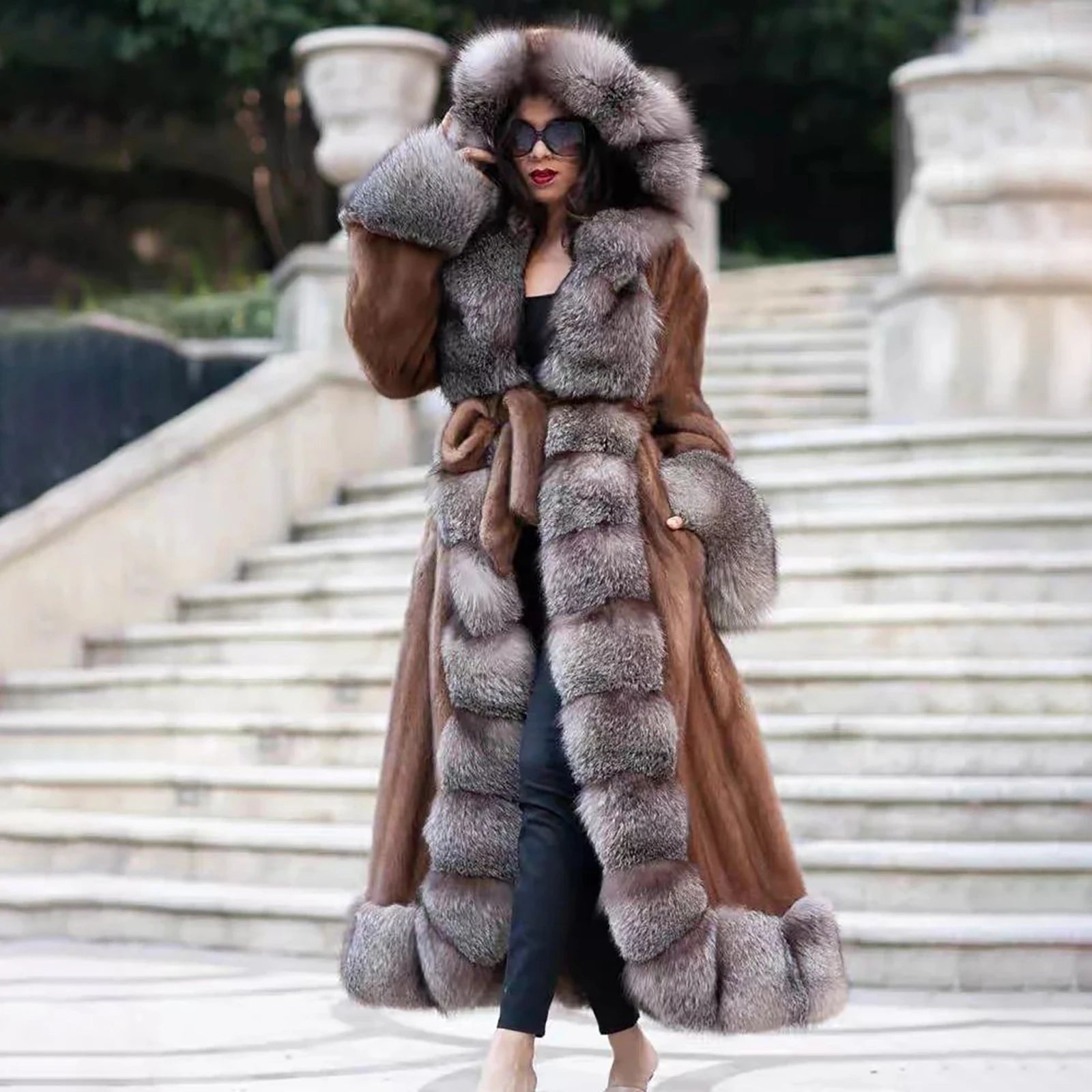 A model wearing a Women's Mink & Crystal Fox Fur Coat, her hand casually resting in the pocket, showcasing the natural fluidity of the mink fur and effortless elegance. From Borcelleclothes.