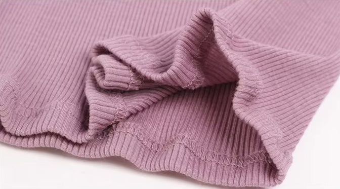 Detailed double-stitching and textured fabric on the bottom of a Women's Mock Neck Wool Top in Lily color, crafted from 100% wool for chic style and seasonal flexibility. From Borcelleclothes.