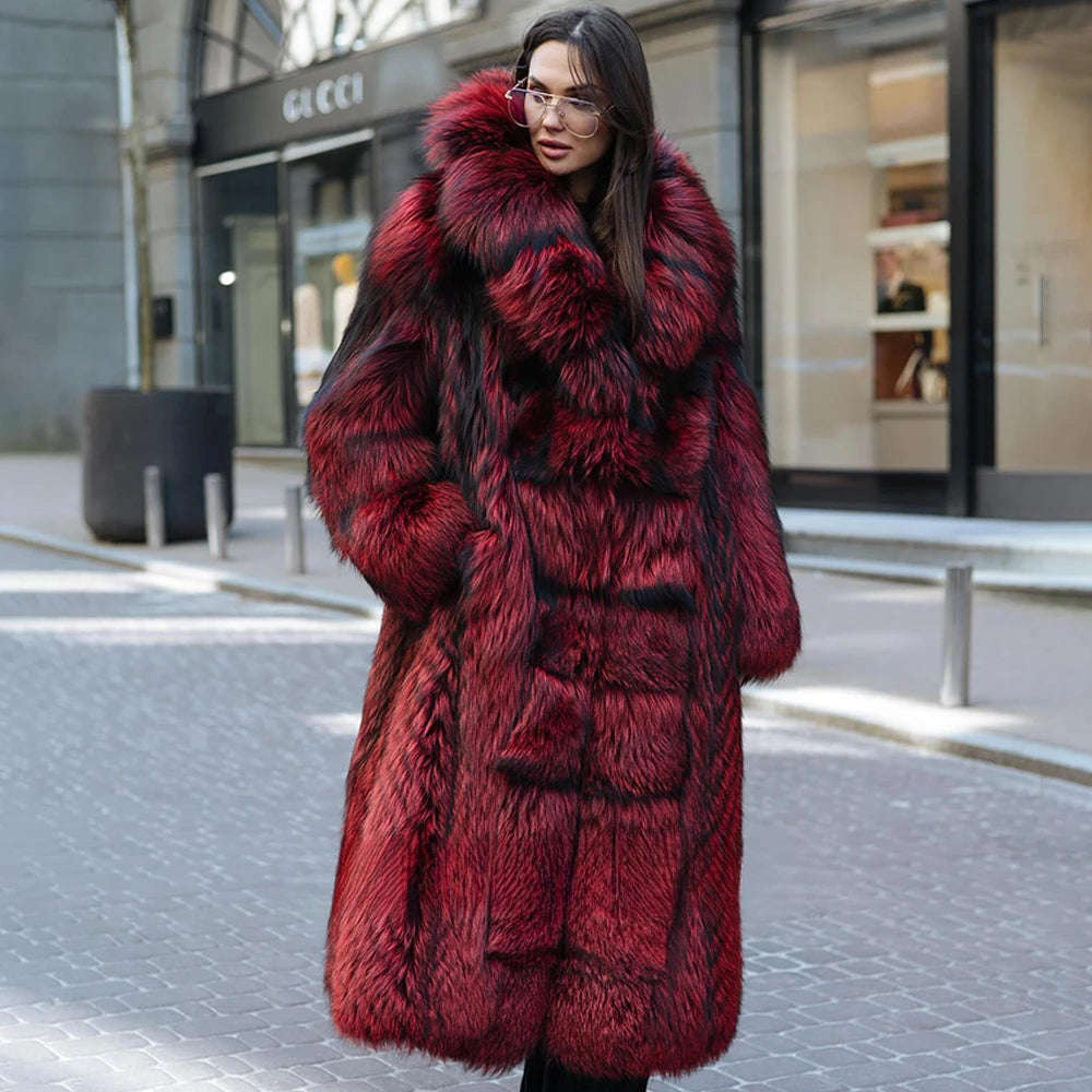 A model wearing a Women's Monarch Silver Fox Fur Coat, her hand resting in the pocket, highlighting the voluminous texture of silver fox fur and the richness of Monarch red. From Borcelleclothes.