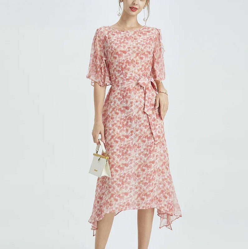 Model holding a small white bag—contrasting the rose-toned chiffon with a minimalist accessory. From Borcelleclothes.