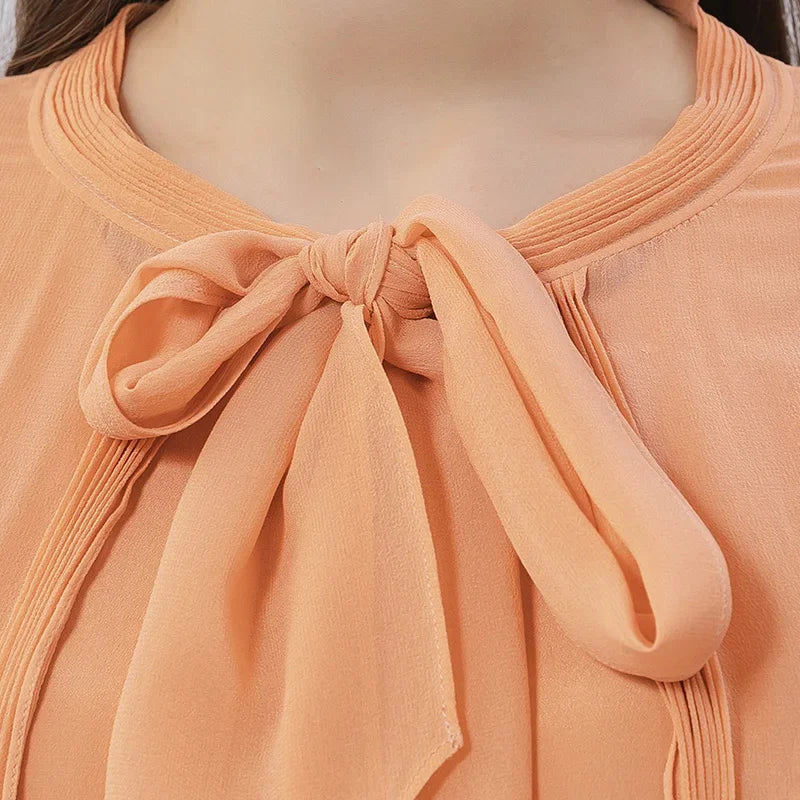 Upper front view of the cape in Folklore Rose silk with pintucked neckline and flowing silhouette. From Borcelleclothes.