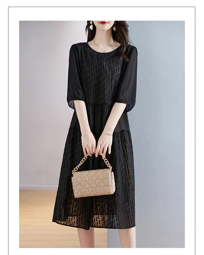 Model wearing the Onyx georgette dress with a small bag—contrasting the dress’s depth and light play with a minimalist accessory. From Borcelleclothes.